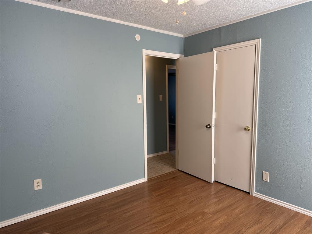 2414 March Lane Grand Prairie, TX 75050 - Photo 12 of 15 a view of an empty room with wooden floor and closet