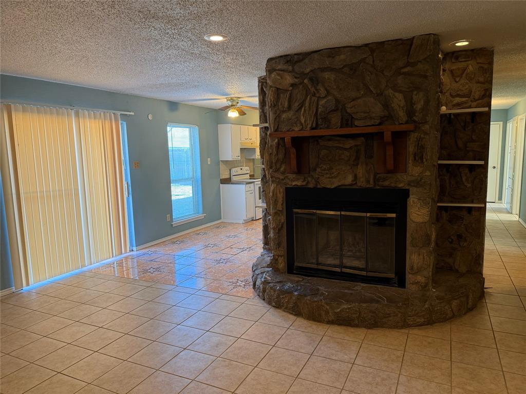2414 March Lane Grand Prairie, TX 75050 - Photo 4 of 15 a kitchen with granite countertop a stove and a fireplace