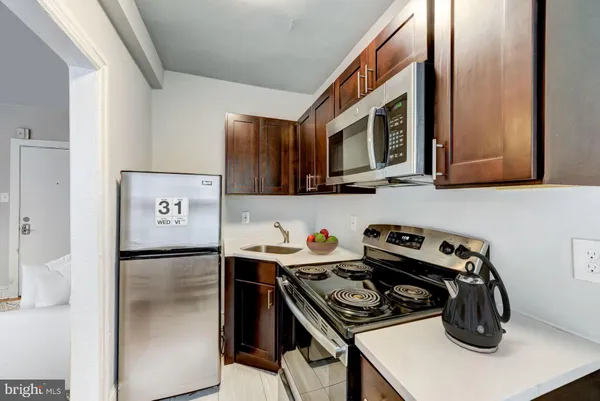 a kitchen with stainless steel appliances granite countertop a stove a refrigerator and a sink
