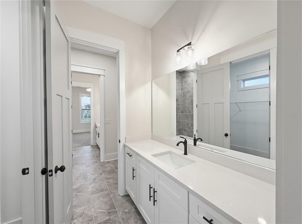 303 Eminence Peak Rydal, GA 30171 - Photo 58 of 73 a bathroom with a double vanity sink a mirror and a shower