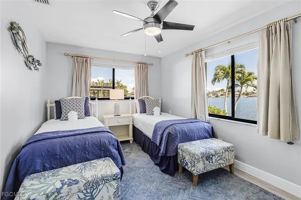 a bedroom with two beds and a large window