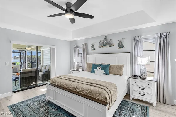 a bedroom with a large bed and a chandelier fan
