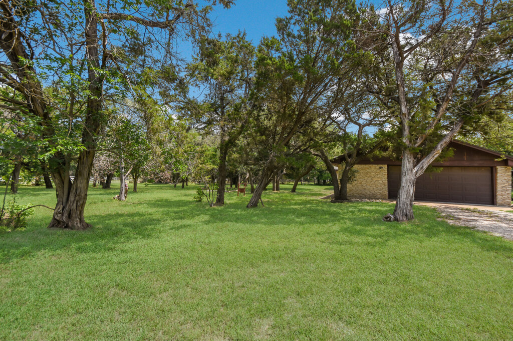 301 Navajo Trail Georgetown, TX 78633 - Photo 11 of 35 View of grassy yard featuring dirt driveway and an attached garage