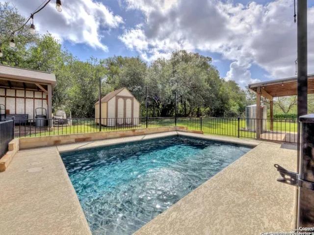 a view of a house with backyard sitting area and garden