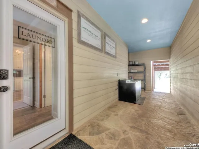 a view of hallway with couch and a ceiling fan