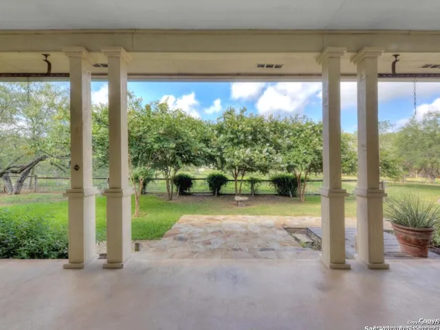 an empty room with wooden floor fireplace and windows