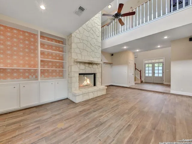 a view of an empty room with a fireplace and a window