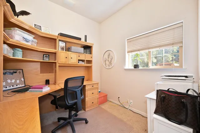 a view of a workspace with furniture and a window