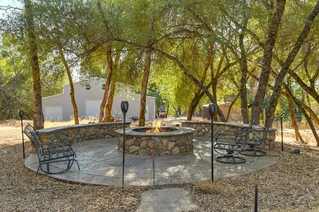 a view of house with backyard and sitting area