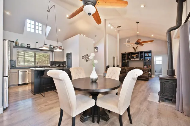 a dining room with furniture a kitchen and chandelier