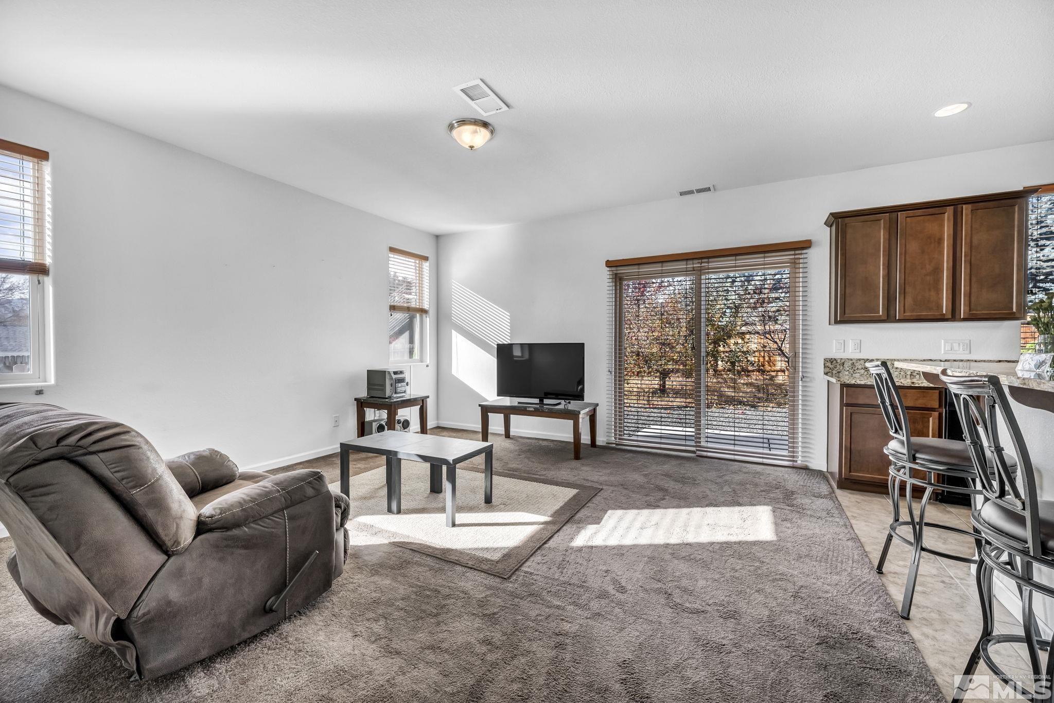 2705 Gulling Court Reno, NV 89503 - Photo 27 of 40 a living room with furniture a flat screen tv and a large window