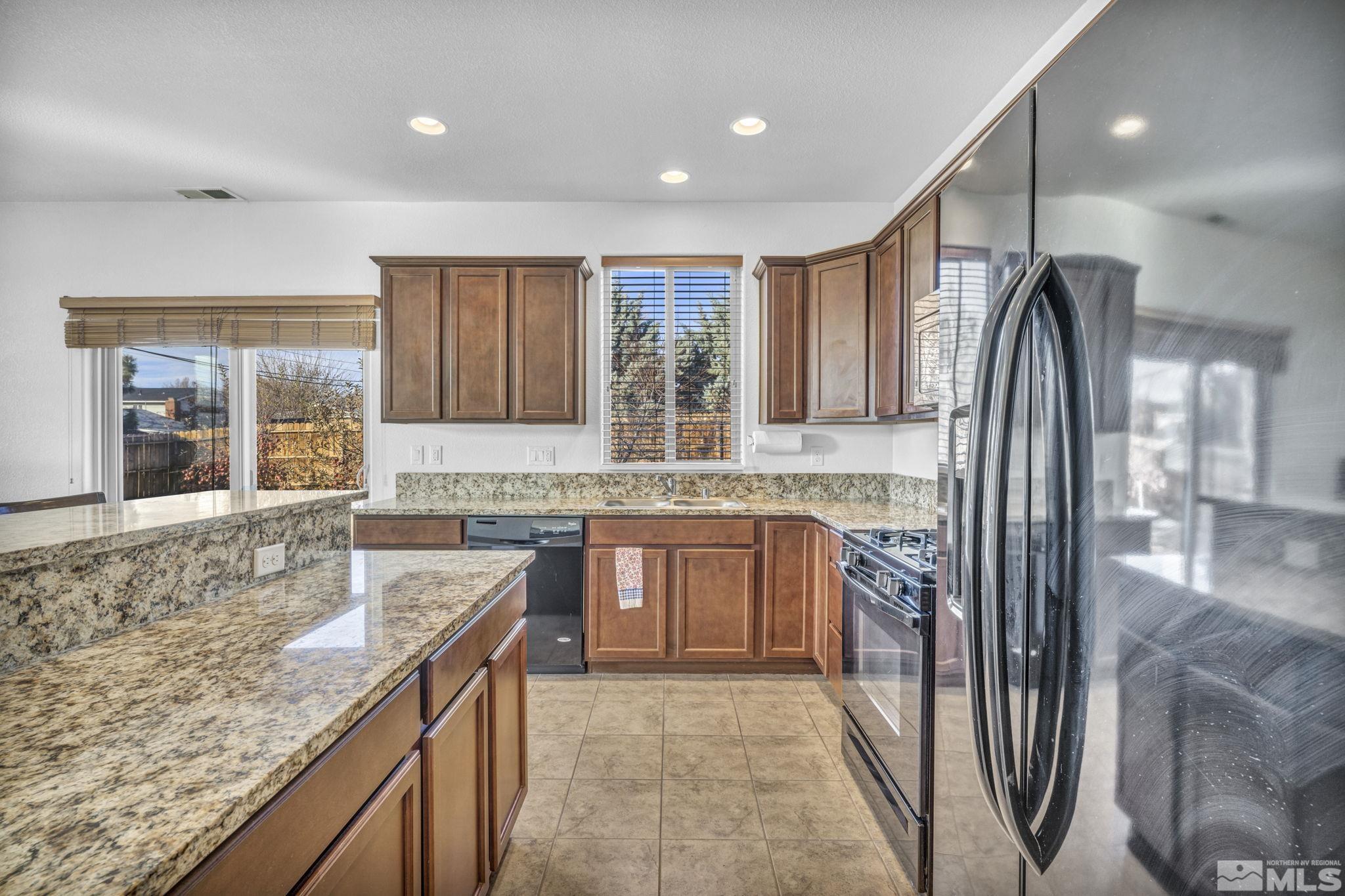 2705 Gulling Court Reno, NV 89503 - Photo 6 of 40 a kitchen with stainless steel appliances granite countertop refrigerator sink and cabinets