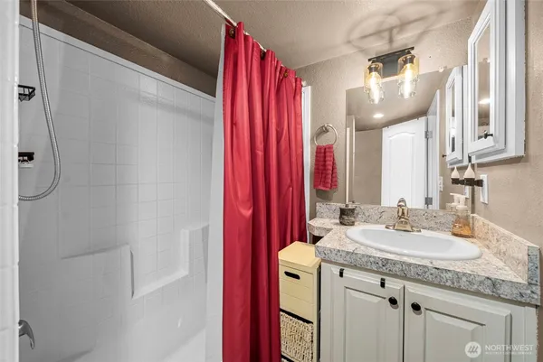a bathroom with a granite countertop sink and a mirror