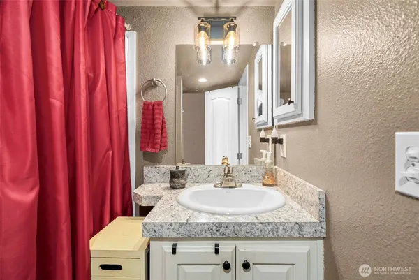 a bathroom with a granite countertop sink and a mirror