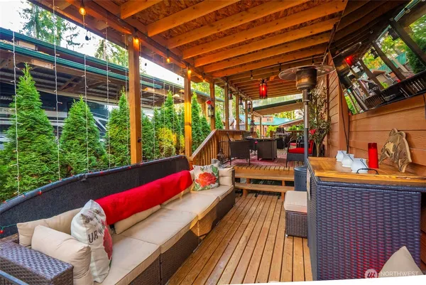 a sitting area with lots of potted plants in front of it