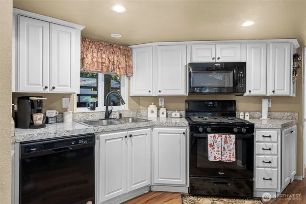 a kitchen with stainless steel appliances granite countertop a stove a sink and a microwave