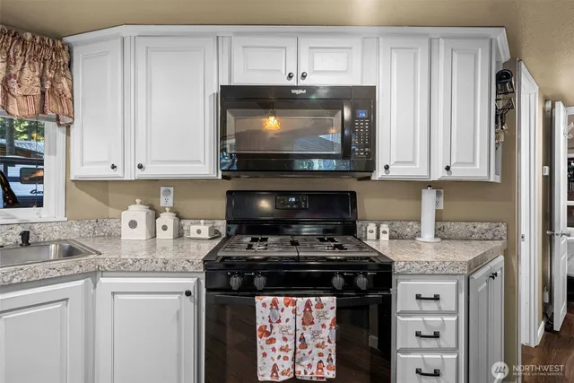 a kitchen with stainless steel appliances granite countertop a stove and a microwave