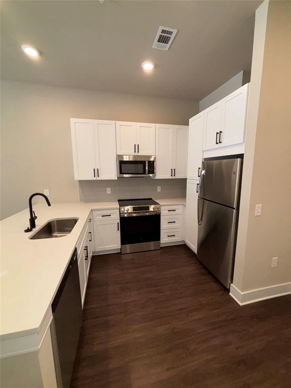 111 Town Place, Unit 2610 Fairview, TX 75069 - Photo 2 of 31 a kitchen with a sink a refrigerator a microwave and cabinets
