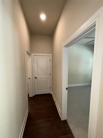 a view of a hallway with wooden floor and staircase