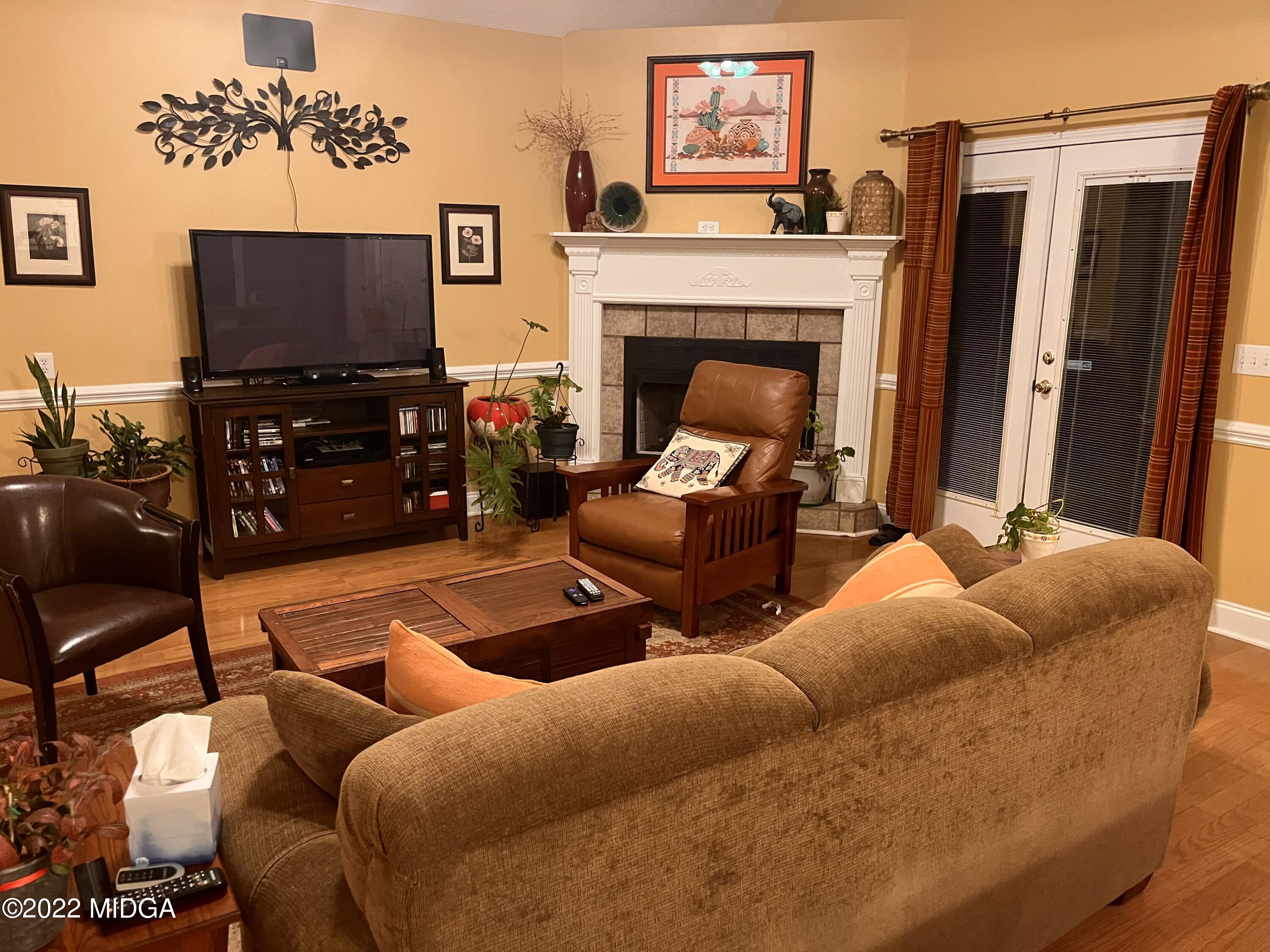 1277 Johnson Road Macon, GA 31220 - Photo 9 of 22 a living room with furniture a flat screen tv and a fireplace