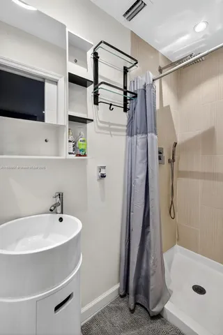 a bathroom with a sink a mirror and shower