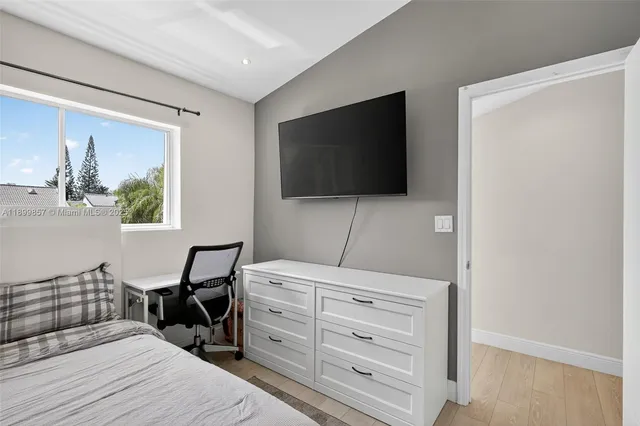 a bedroom with a bed and a flat screen tv