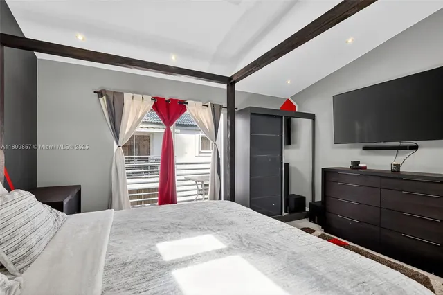 a bedroom with a bed and a flat screen tv