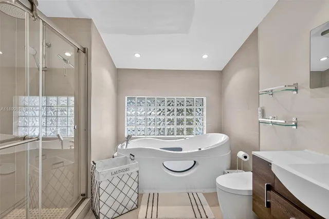 a bathroom with a sink a toilet a mirror and shower