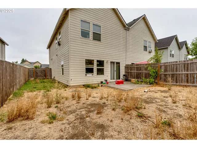 a view of a house with backyard and wooden fence