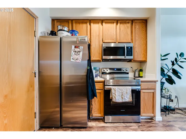a kitchen with stainless steel appliances granite countertop a refrigerator and a stove top oven