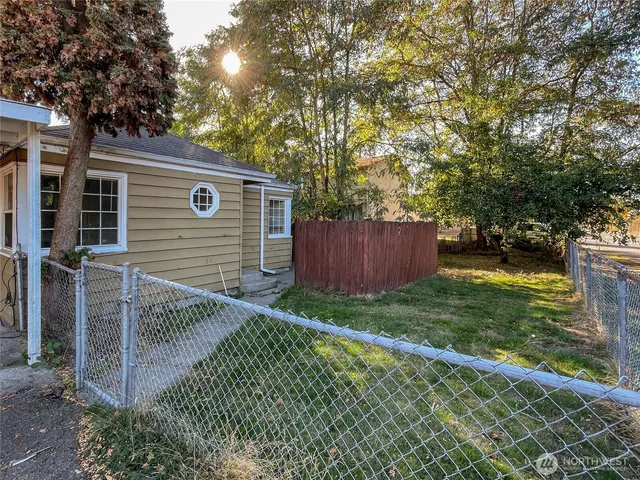 a view of backyard with small cabin and wooden fence