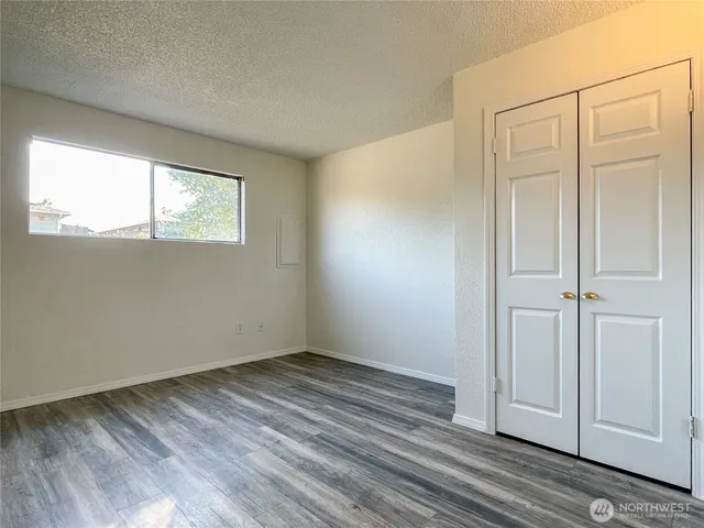 a view of an empty room with closet and a window