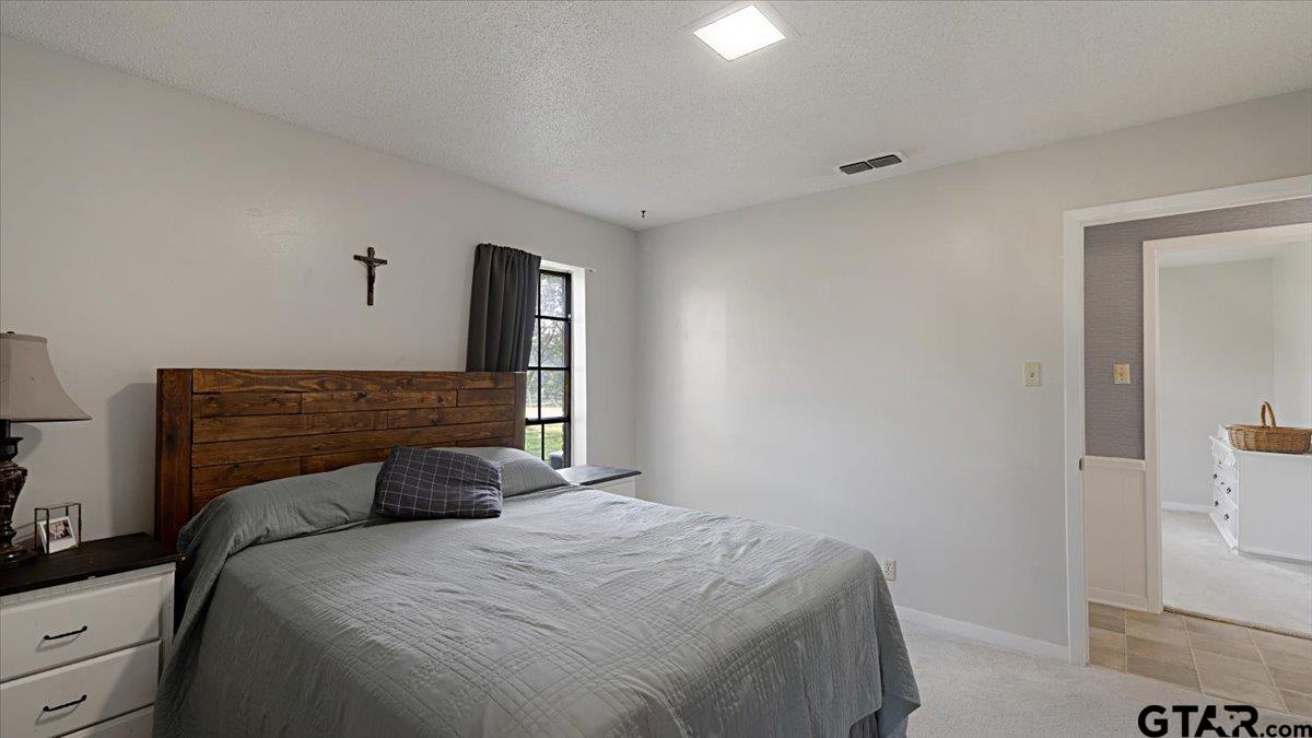 8192 County Road 428 Tyler, TX 75704 - Photo 16 of 38 a bedroom with a bed and mirror