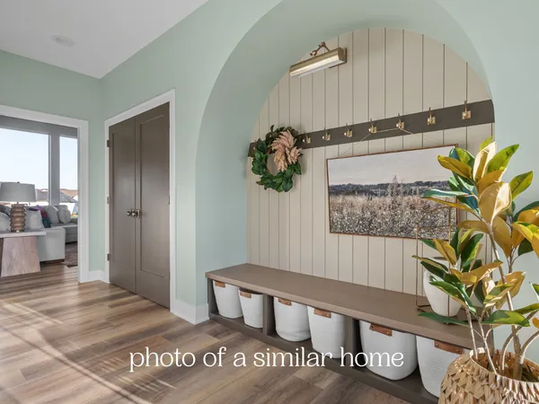 a view of a hallway with wooden floor and furniture