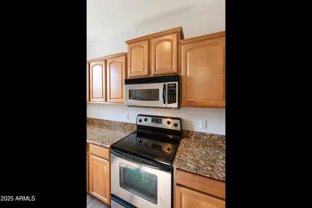 a kitchen with stainless steel appliances granite countertop a stove top oven microwave and cabinets
