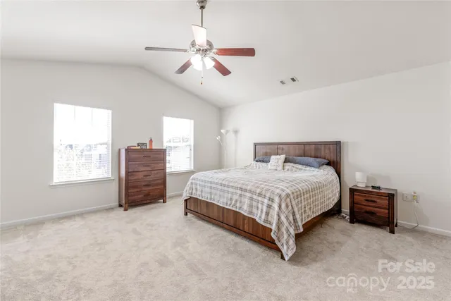 a spacious bedroom with a bed and a chandelier