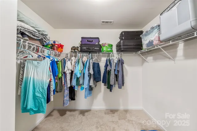 a view of walk in closet with clothes