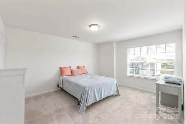 a bedroom with a bed and a large window