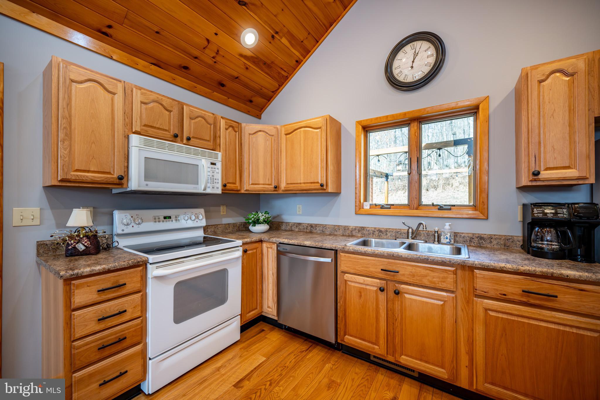 167 Sears Lane Swanton, MD 21561 - Photo 13 of 48 a kitchen with stainless steel appliances granite countertop a stove a sink and dishwasher with wooden cabinets
