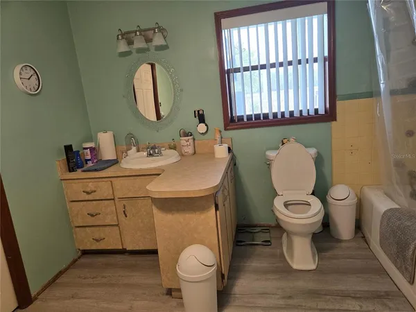 a bathroom with a toilet sink vanity and mirror