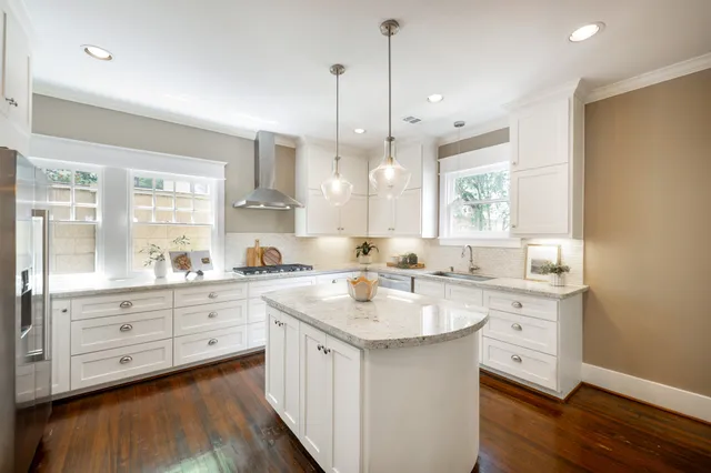 a kitchen with a stove a sink a center island and a window