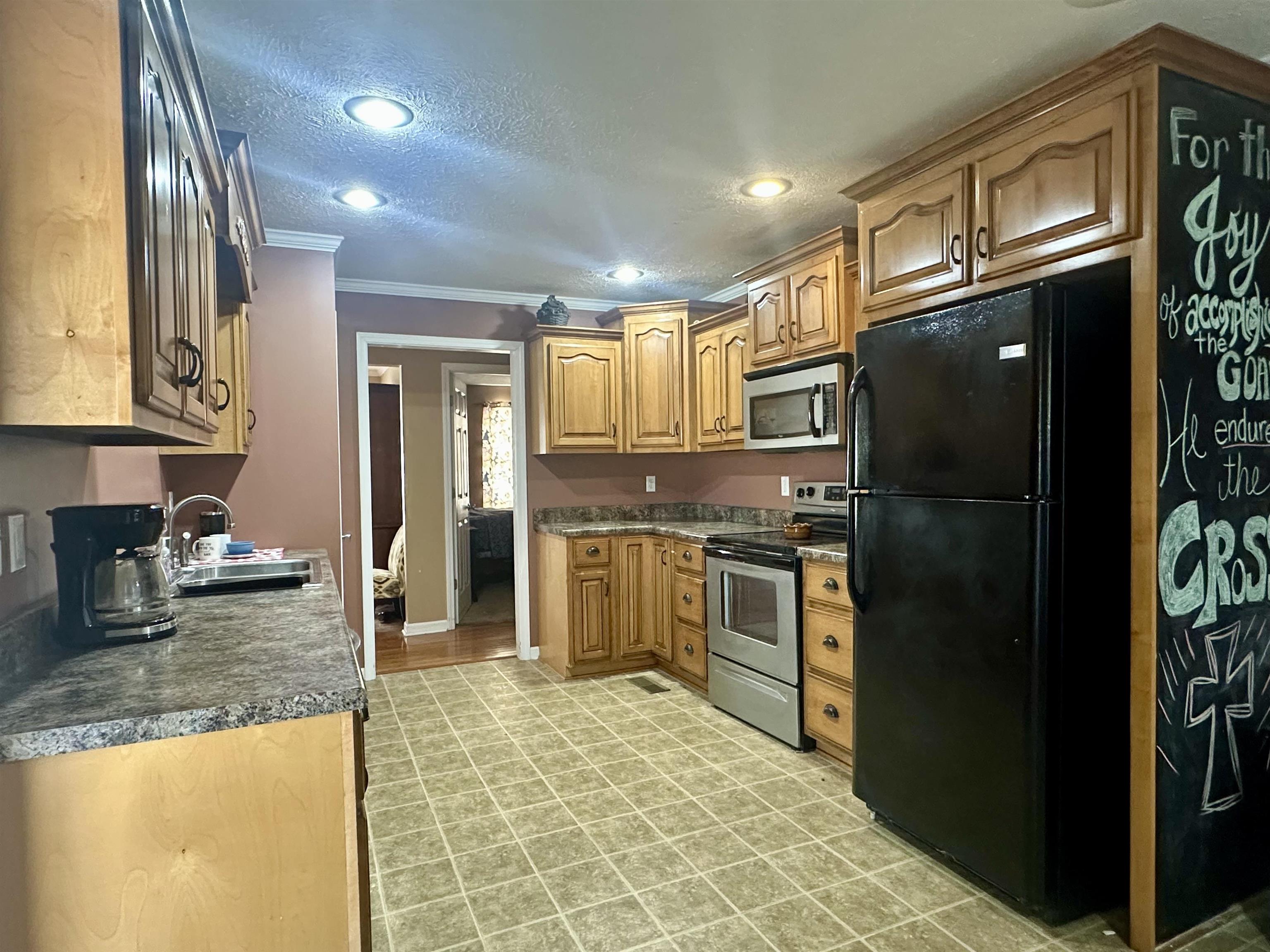 133 Arrowhead Trail Adamsville, TN 38310 - Photo 8 of 24 Kitchen with sink, a textured ceiling, appliances with stainless steel finishes, and crown molding