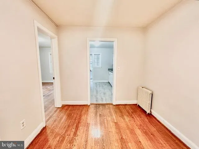 a view of a room with wooden floor and a bathroom