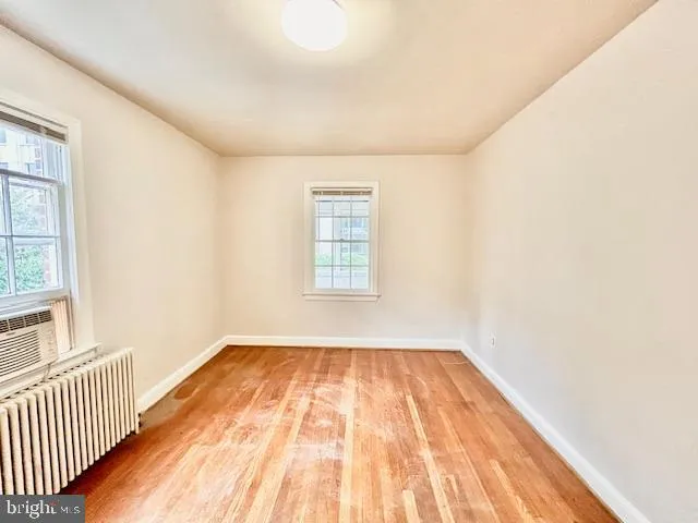 a view of a room with wooden floor and windows