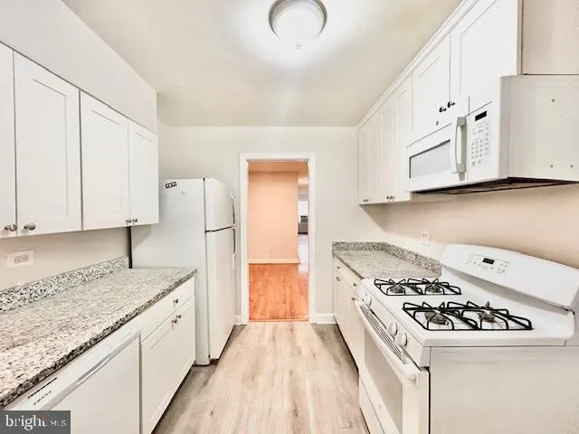 a kitchen with granite countertop a sink a stove and refrigerator