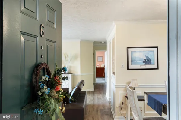 a view of a hallway with wooden floor and a chandelier
