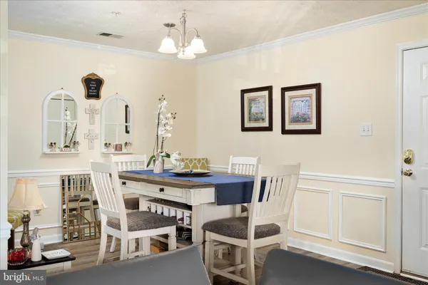 a view of a dining room with furniture and chandelier