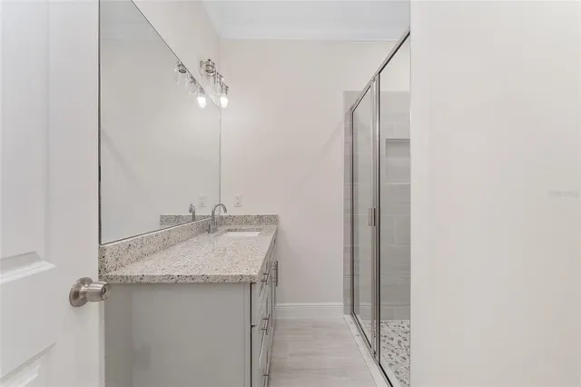 a bathroom with a granite countertop sink and a mirror