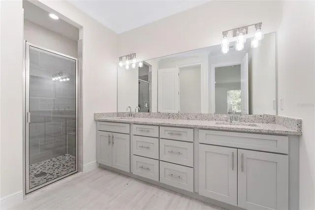 a bathroom with double sink and a mirror