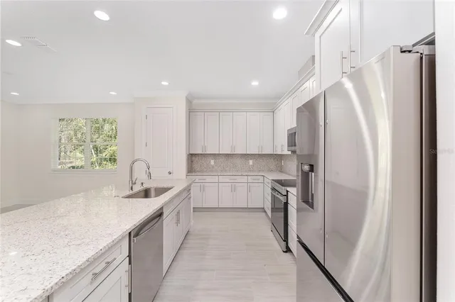 a kitchen with white cabinets and stainless steel appliances